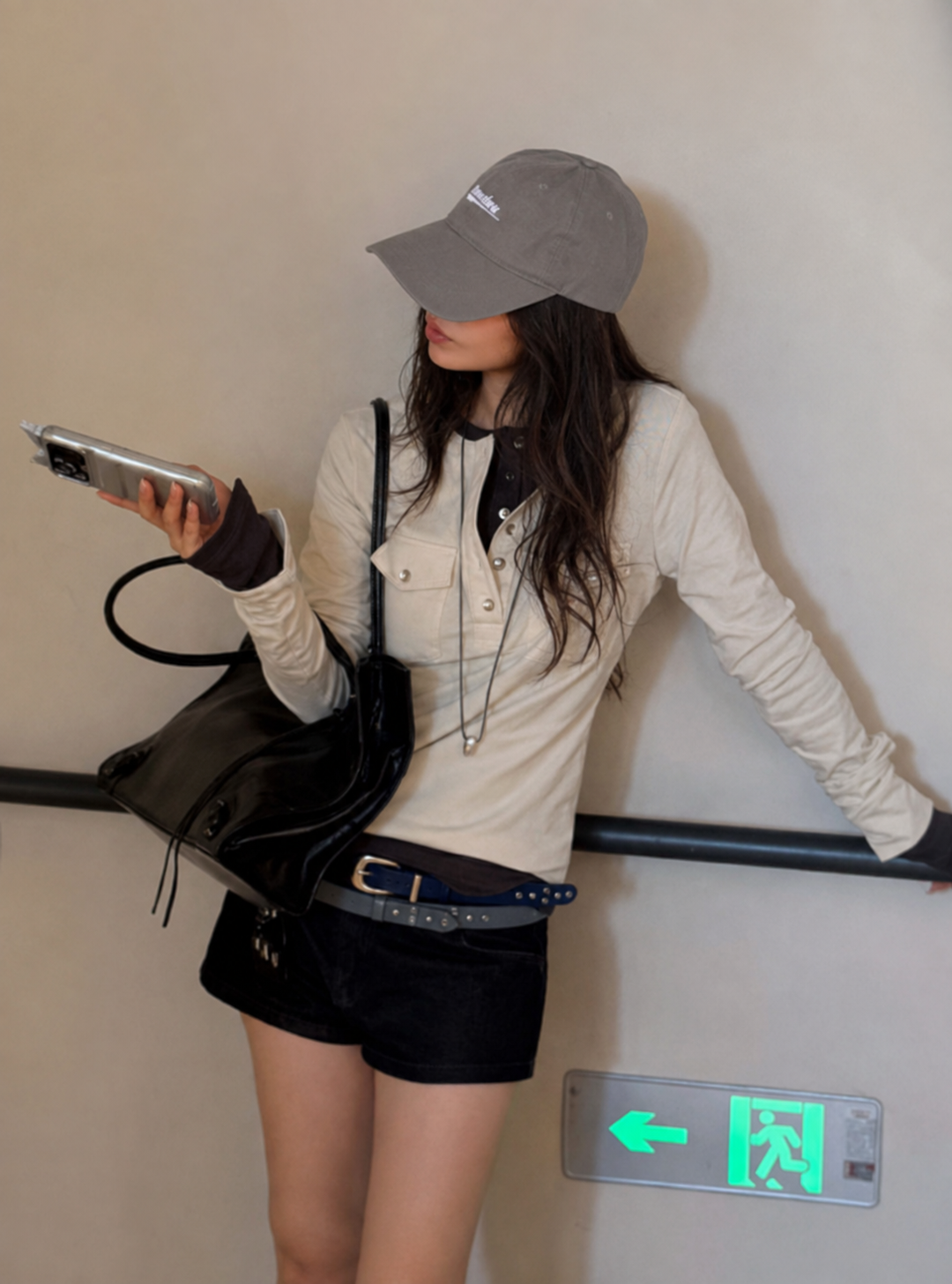 Side profile of the Florise Studio Vintage Utility Henley Top in Ivory Cream, featuring a slim fit silhouette, button-front Henley neckline, utility chest pockets, and soft stretch cotton fabric paired with black denim shorts.