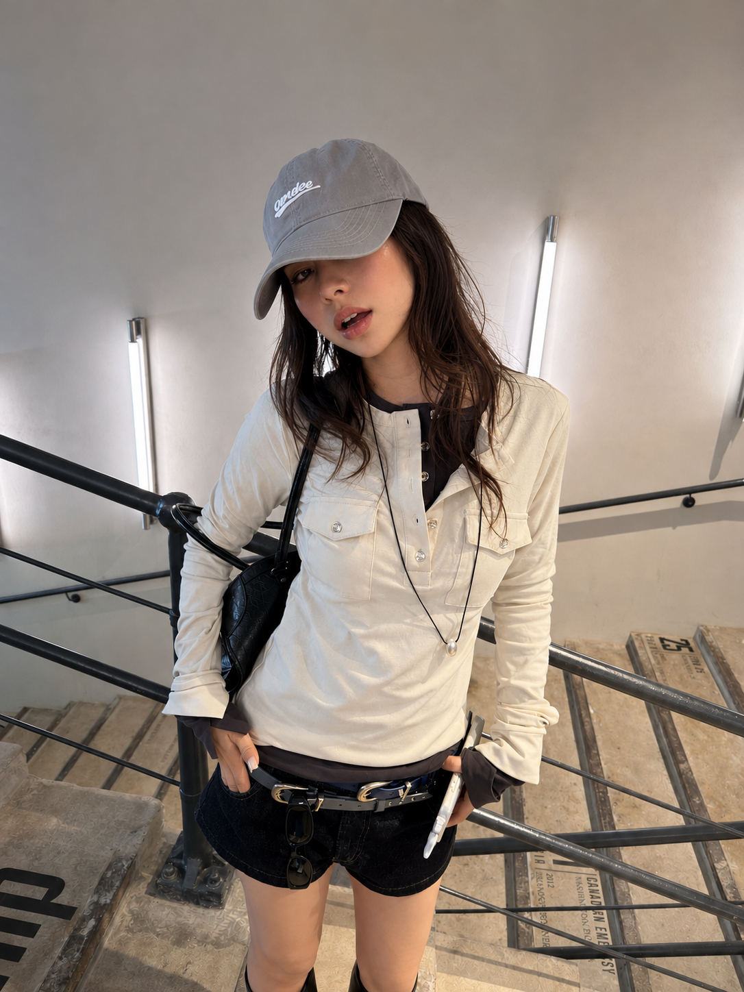 Model wearing the Florise Studio Vintage Utility Henley Top in Ivory Cream, featuring a slim fit silhouette, button-front Henley neckline, flap chest pockets, and soft stretch cotton fabric styled with black denim shorts.