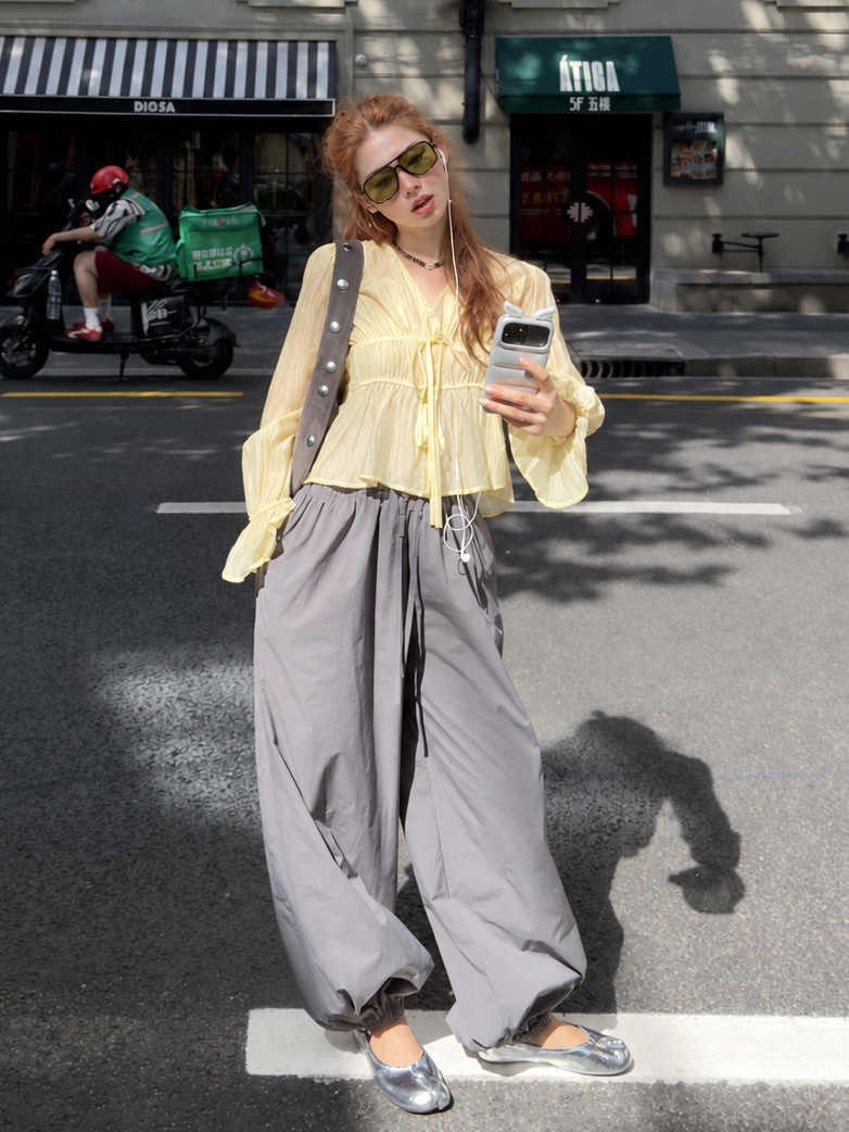 Model styling the Butter Veil Ethereal Drawstring Sheer Blouse with lightweight trousers for an effortless street look.