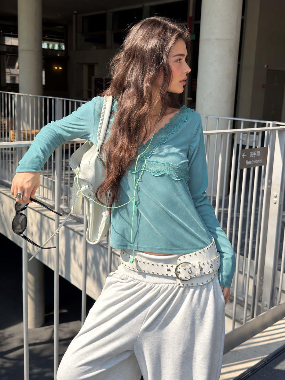 Sage green lace trim V-neck top shown in an outdoor lifestyle look