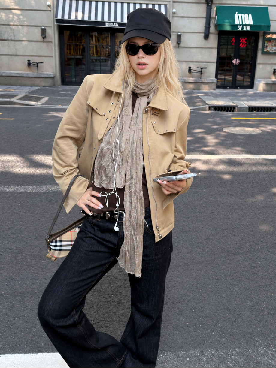 Woman wearing the Florise Studio Vintage Stud Utility Jacket in Desert Sand, featuring silver stud detailing, concealed zip closure, and a relaxed vintage-inspired utility silhouette.