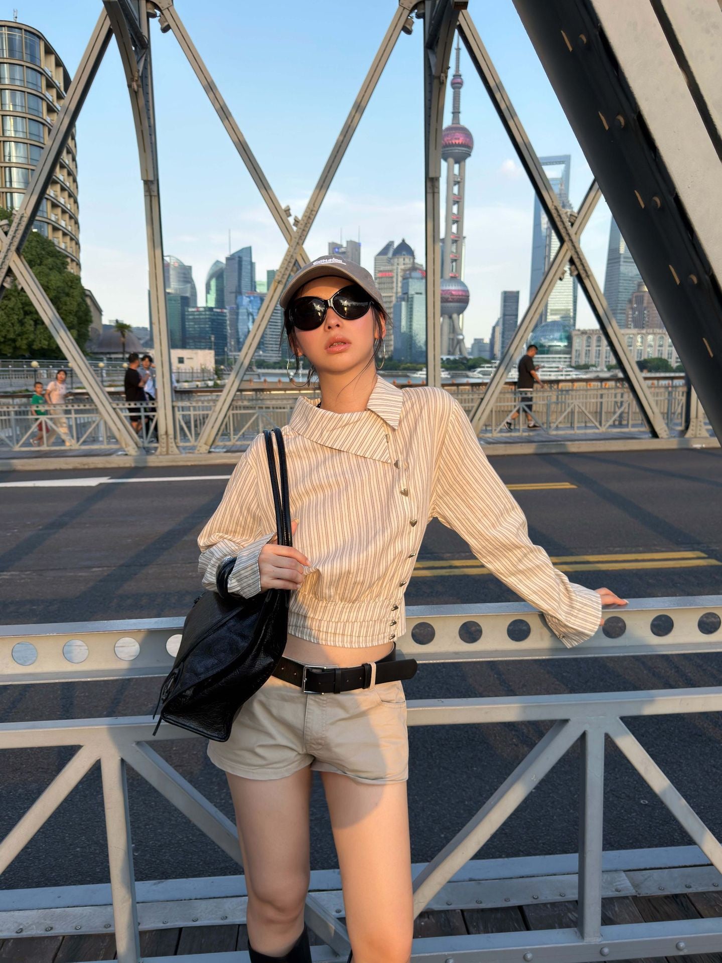Front view of an asymmetric striped cotton shirt with diagonal button closure and cropped fit