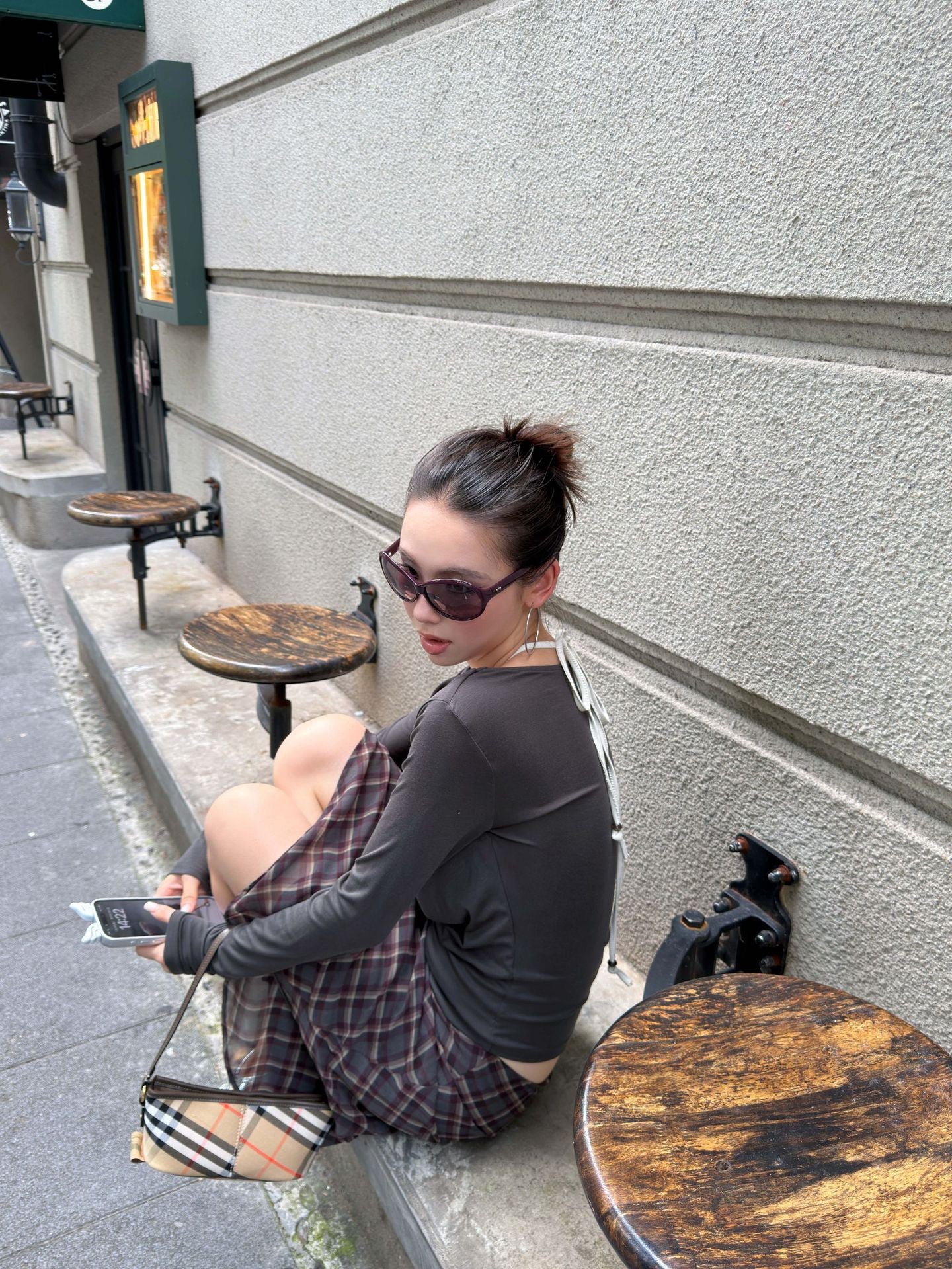 Back and side view of a women's vintage plaid chiffon midi skirt paired with a draped brown top, showcasing the lightweight flowy silhouette.