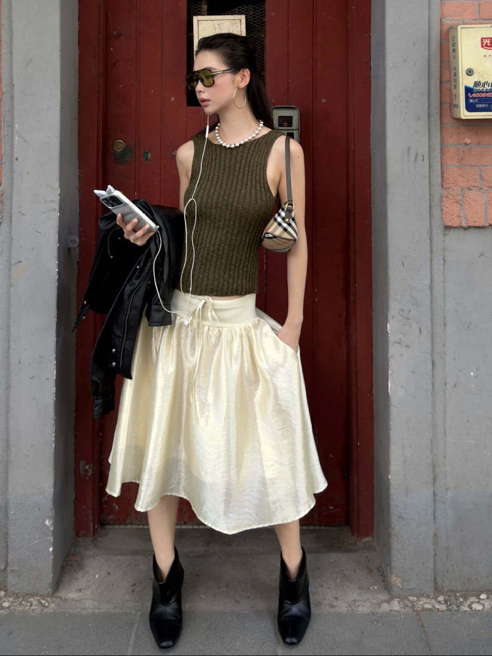 Olive green ribbed knit sleeveless tank top paired with skirt outfit and minimalist street style