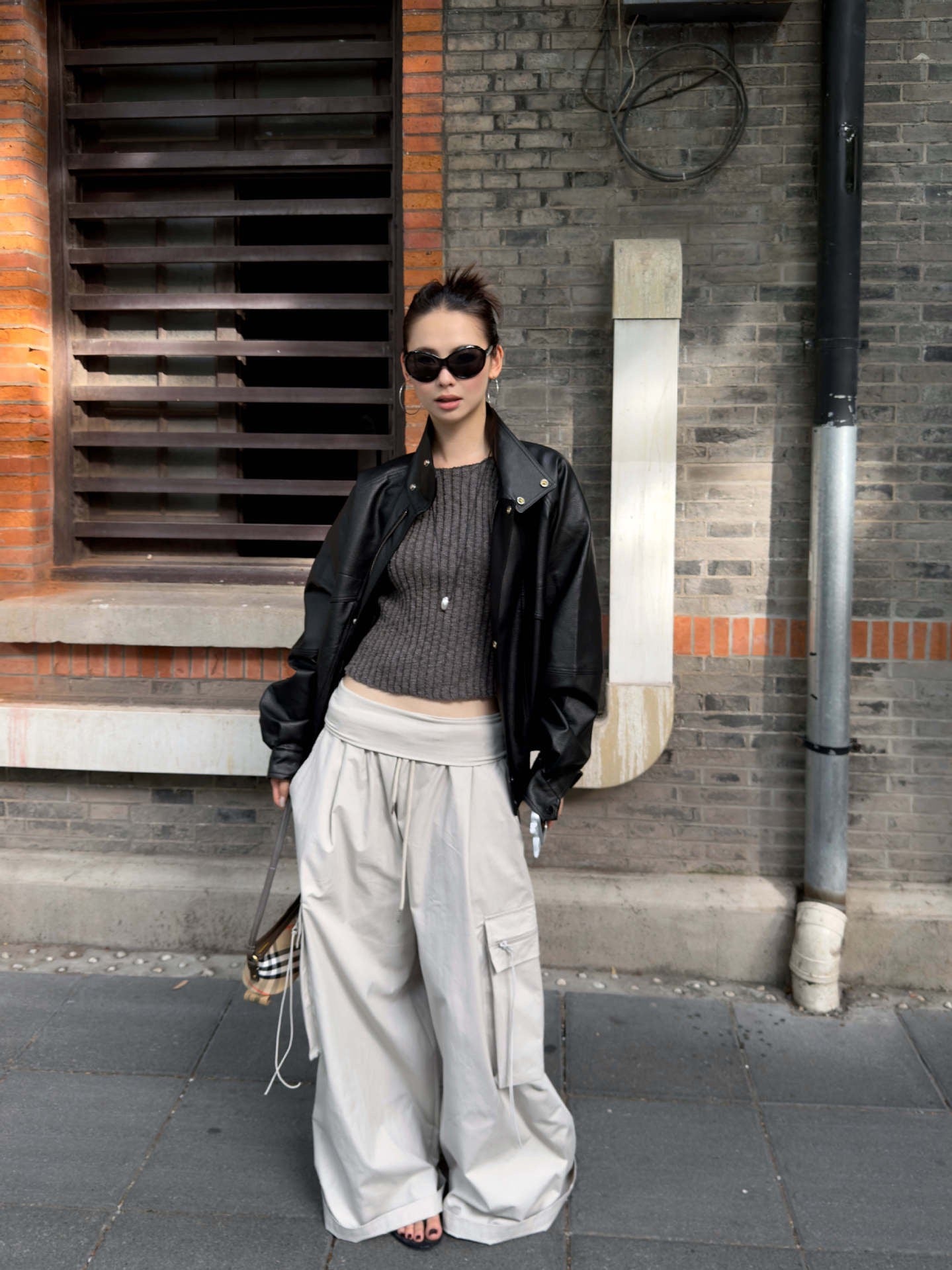 Charcoal gray ribbed knit sleeveless tank top paired with wide leg cargo pants for a minimalist street style look