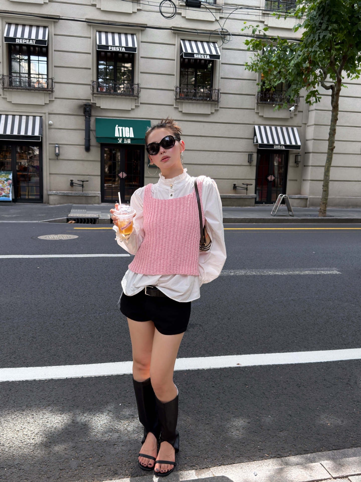 Blush pink ribbed knit sleeveless tank top styled with white blouse and black shorts for feminine casual street style outfit