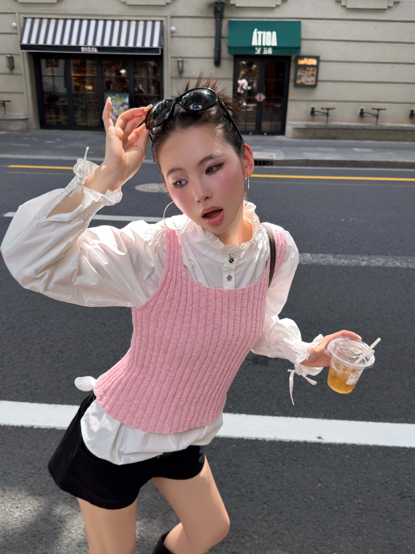 Blush pink ribbed knit sleeveless tank top paired with white shirt and black shorts featuring a trendy layered outfit style