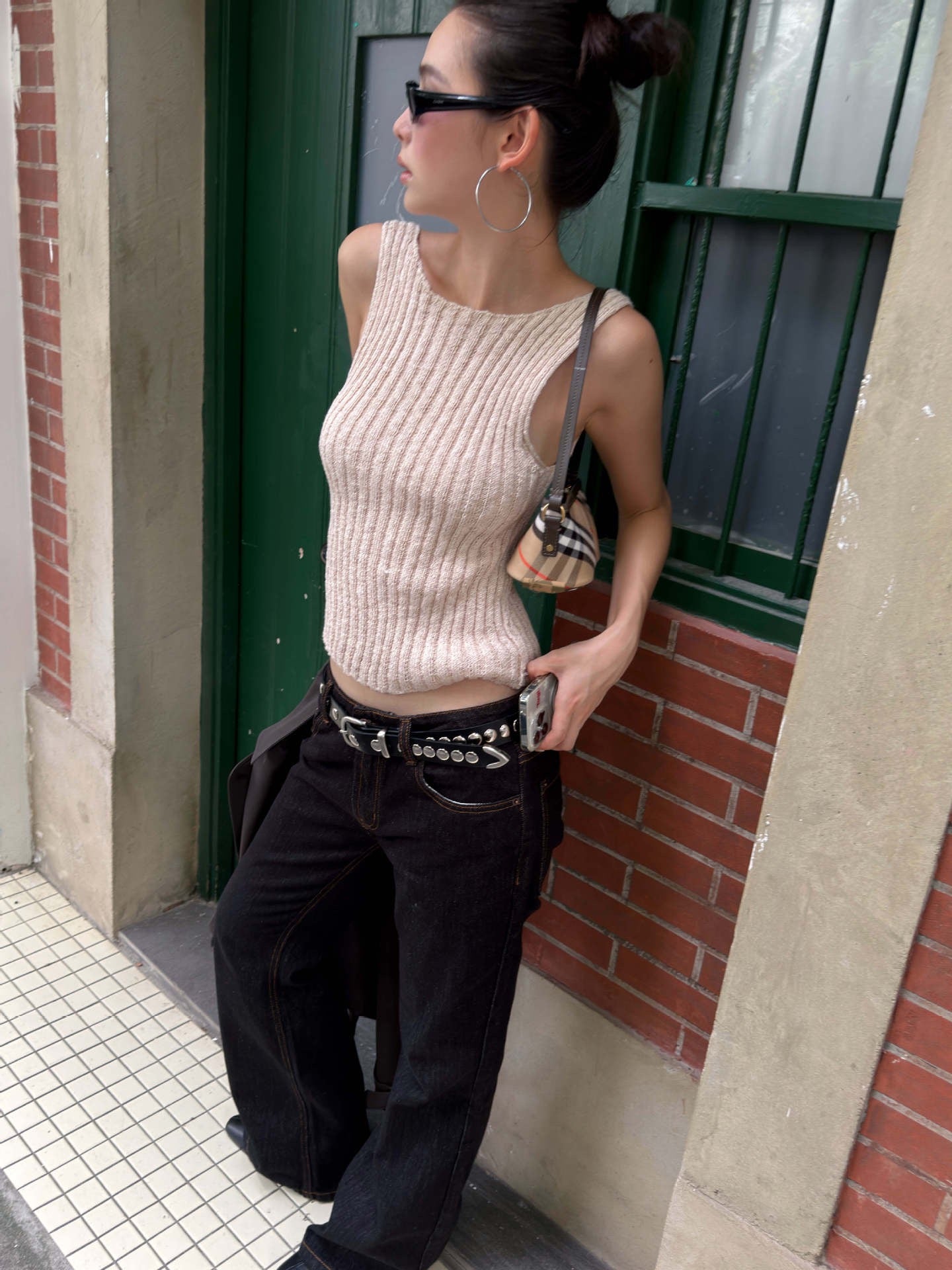Ivory cream ribbed knit sleeveless tank top featuring fitted silhouette and ribbed texture styled with black denim outfit