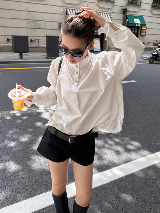 Model Wearing the Ivory White Romantic Ruffle Collar Cotton Blouse with Smocked Shoulders and Balloon Sleeves in a Casual Street Style Look