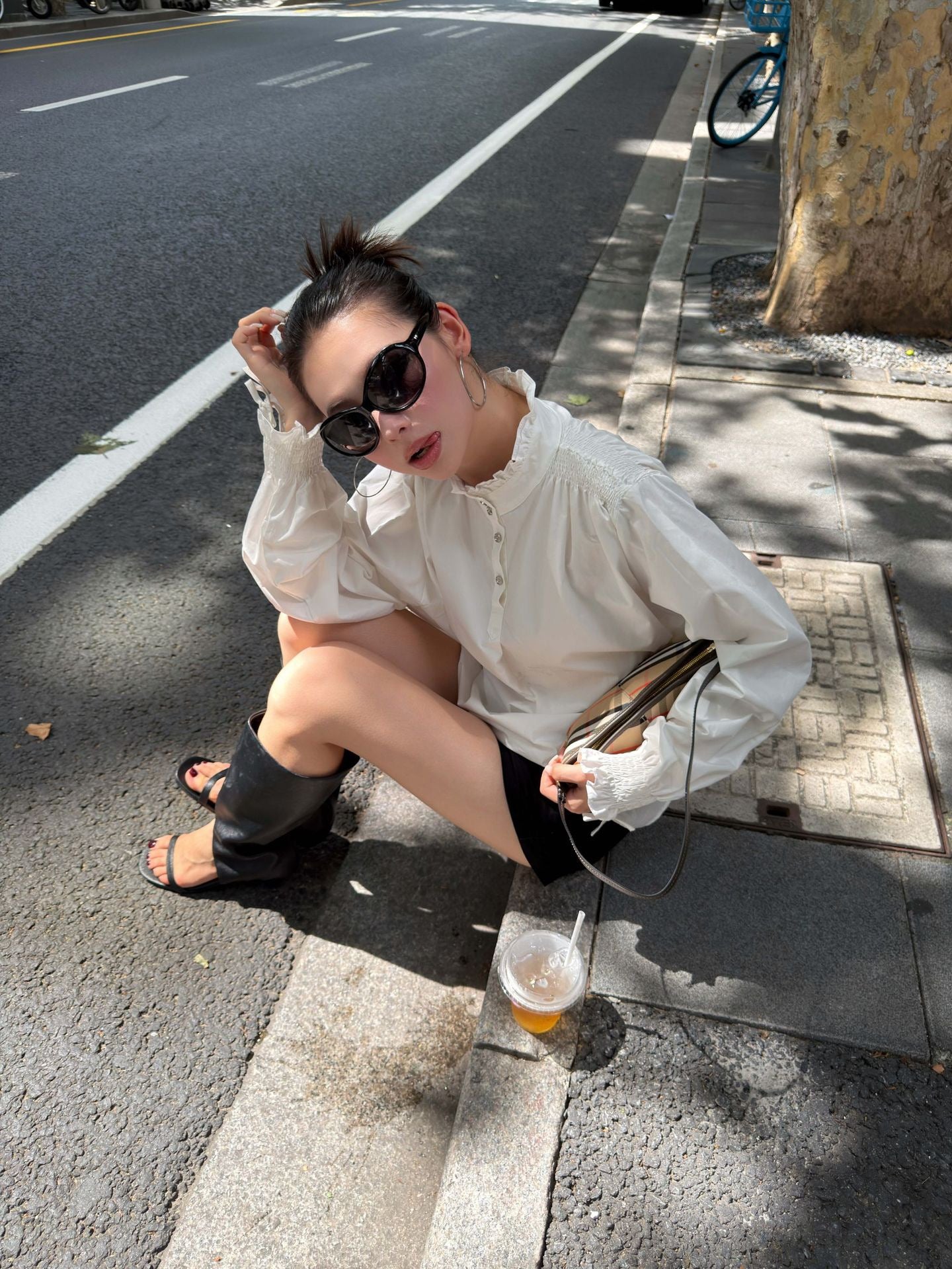 Model Wearing the Ivory White Romantic Ruffle Collar Cotton Blouse with Smocked Shoulders and Balloon Sleeves in a Relaxed Street Style Look