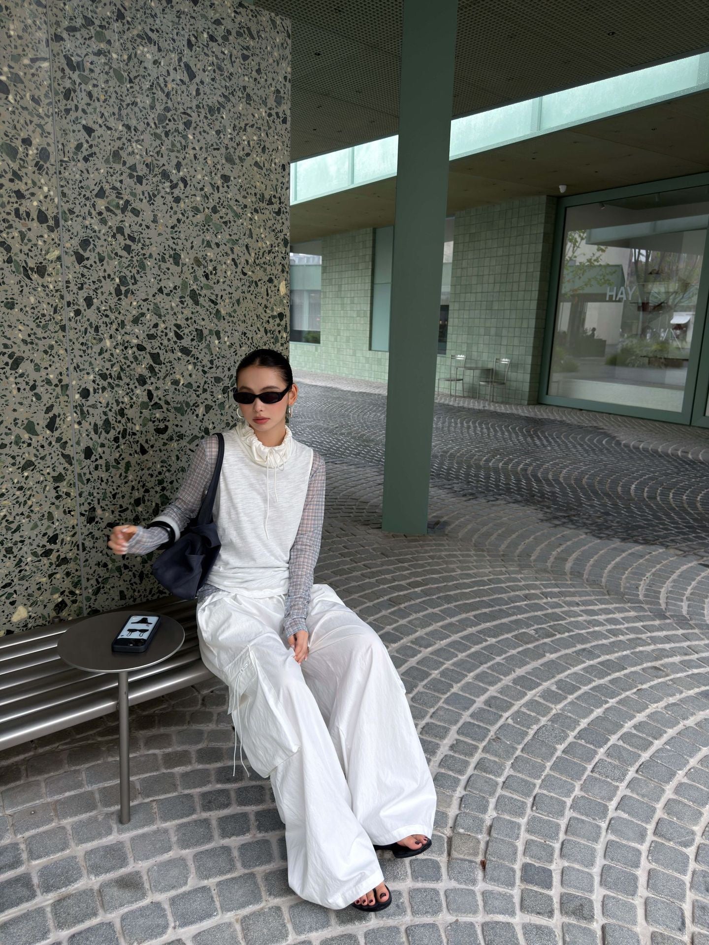 Model seated in Vintage Foldover Waist Wide Leg Cargo Pants in Cloud White, showing the oversized wide leg silhouette and utility cargo pockets.