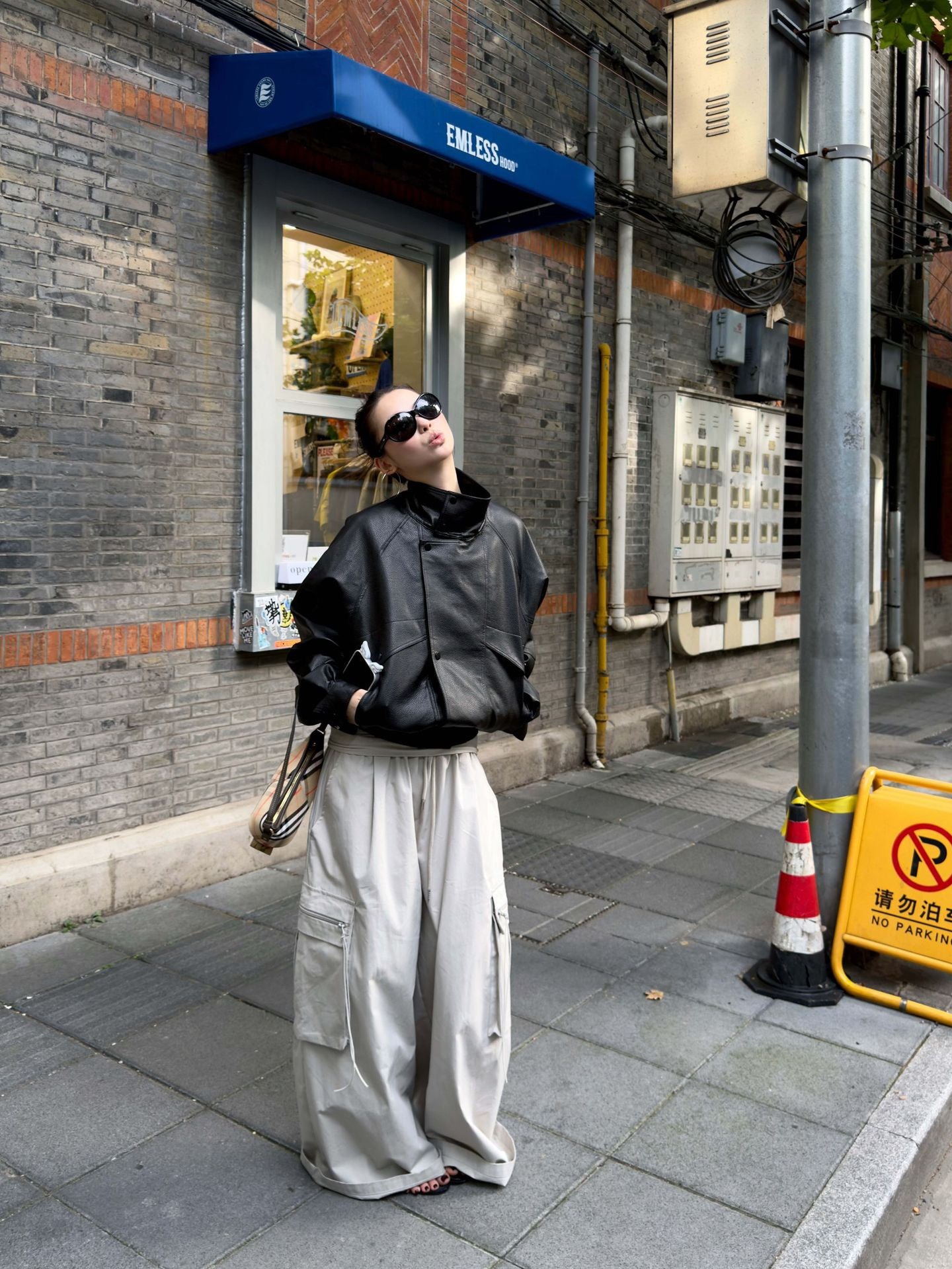 Vintage Foldover Waist Wide Leg Cargo Pants in Stone Mist styled with a black oversized leather jacket for an edgy street style look.