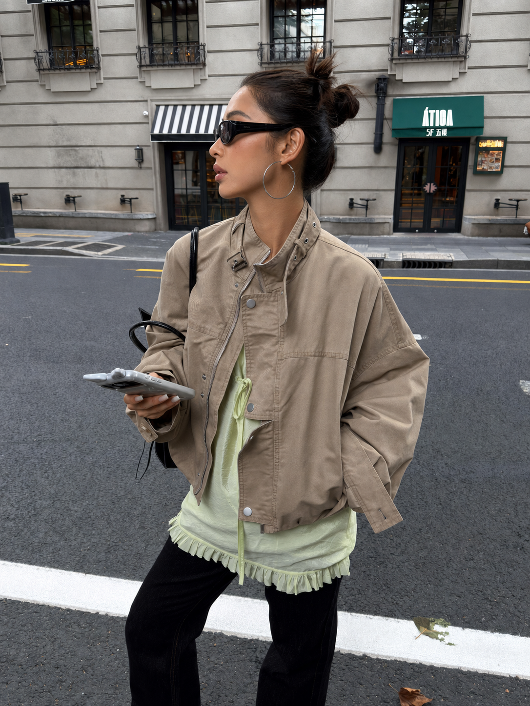 Woman wearing the Florise Studio Oversized Vintage Utility Stand Collar Jacket in Stone Khaki featuring an oversized fit, asymmetric stand collar, premium cotton fabric, and vintage utility styling.