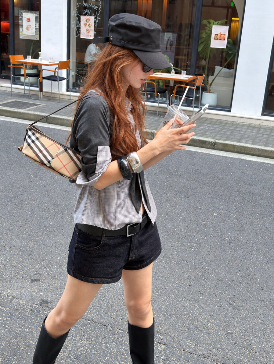 Midnight Indigo low rise denim shorts worn with a sheer white long sleeve top at night.