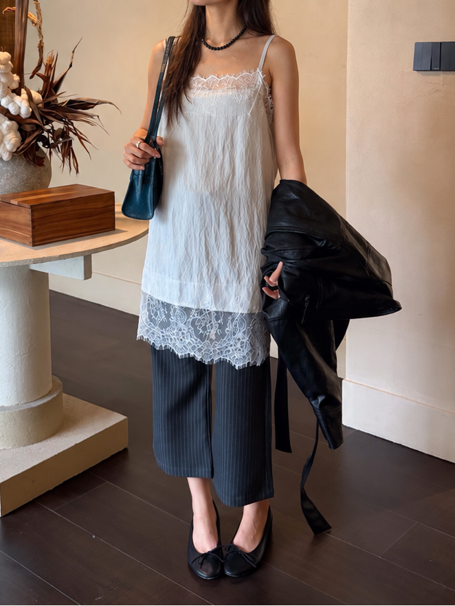 Model wearing the Celeste Lace Layering Slip Dress in Pure White with cropped pinstripe trousers, showcasing delicate floral lace trim and a lightweight layered silhouette.