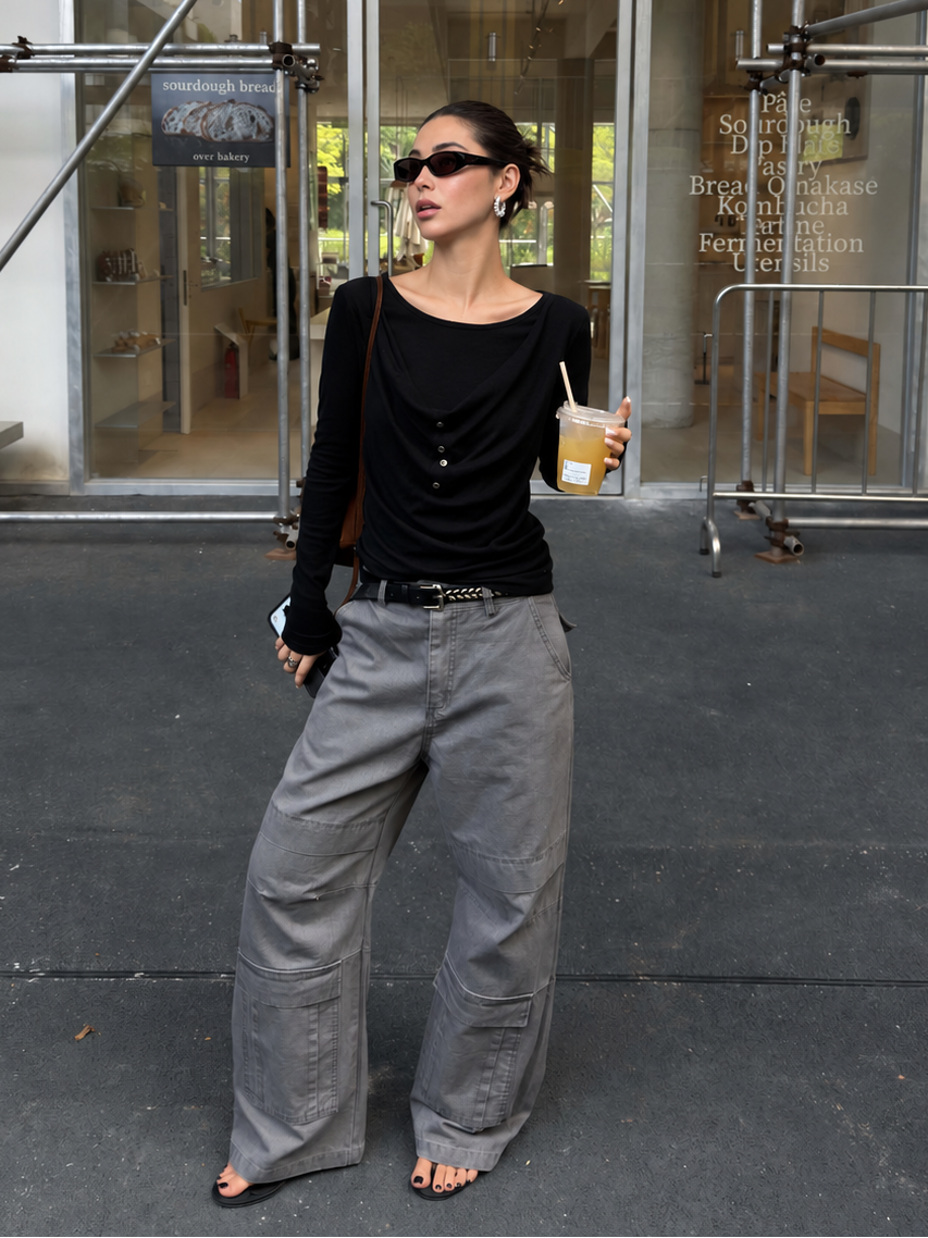 Full-length styling view of black draped button long-sleeve top