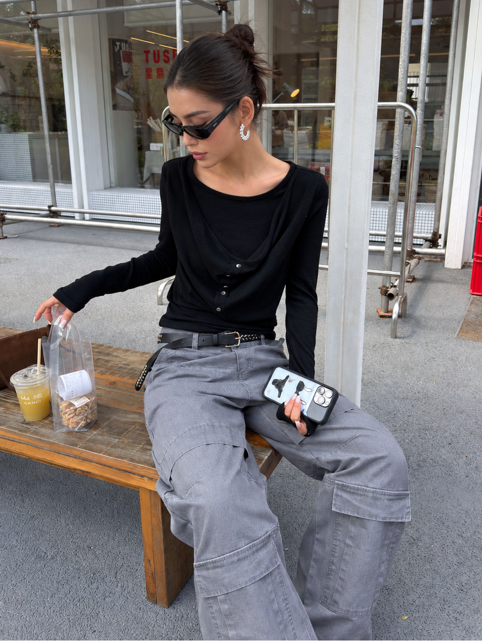 Black draped button long-sleeve top styled with gray cargo pants