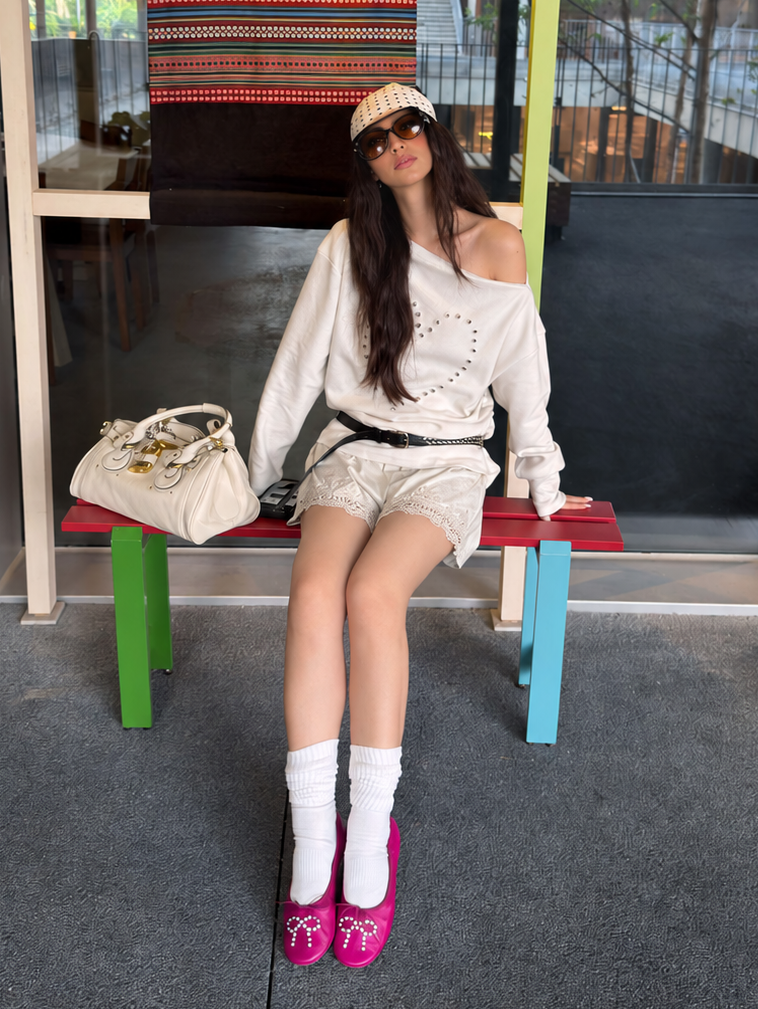 Ivory lace-trim shorts in a seated styling view