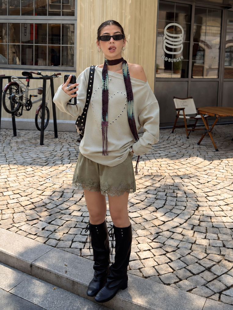 Sage green lace-trim shorts in a full street styling view