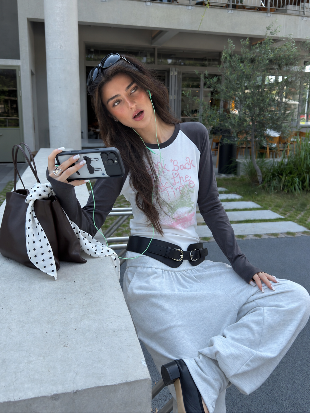 Look Back graphic raglan top in white and charcoal – seated view showing long cuffs