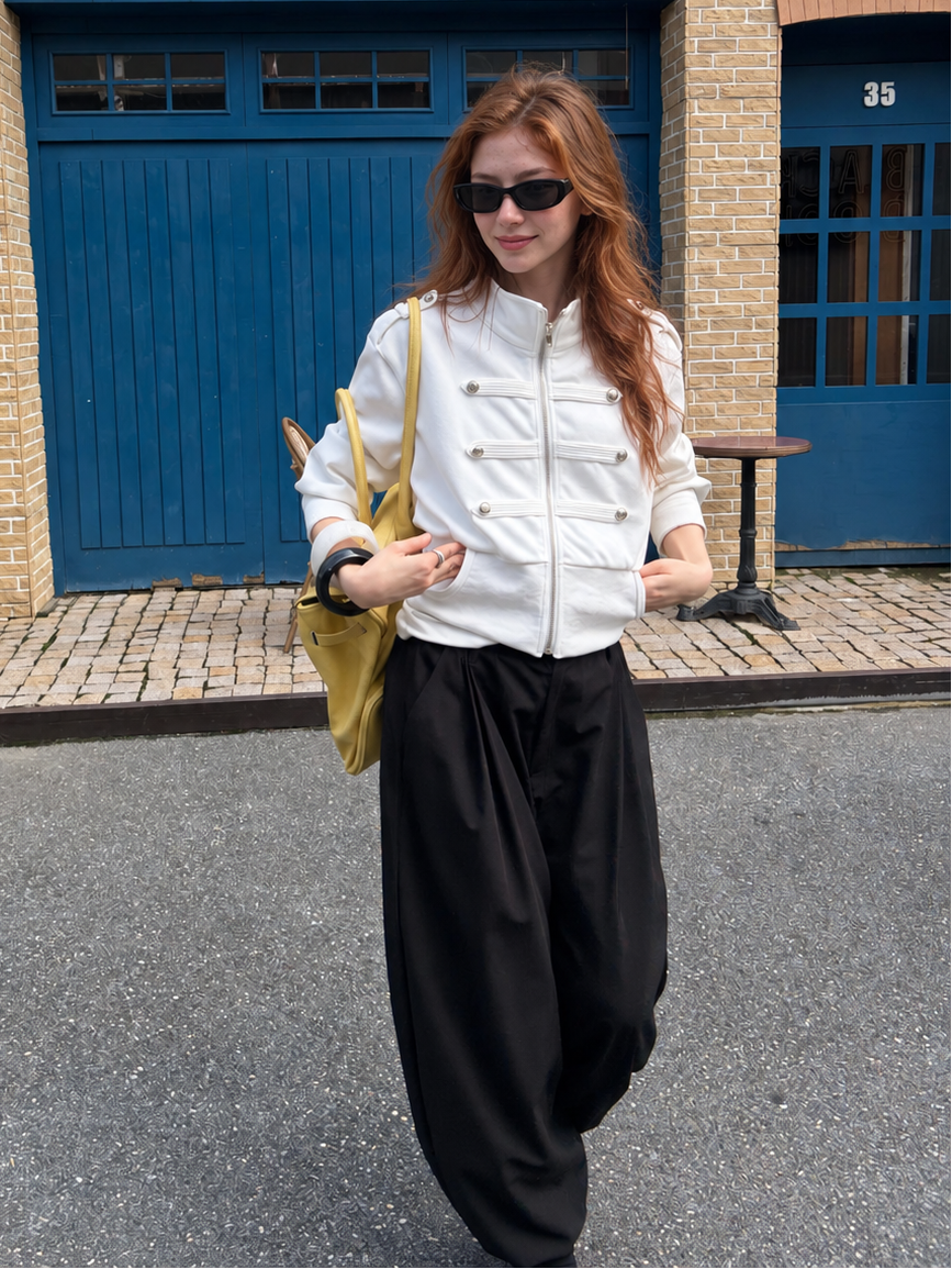 Model styling the Florise Studio Military Cropped Jacket in Ivory White with relaxed black trousers, showcasing the cropped silhouette and tailored finish.