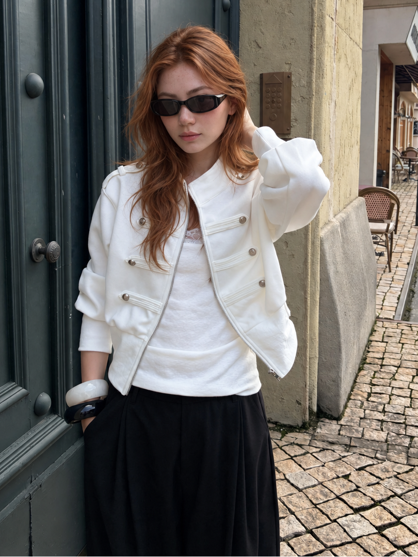 Model wearing the Florise Studio Military Cropped Jacket in Ivory White with a minimalist outfit, featuring decorative silver buttons and a fitted waistband.
