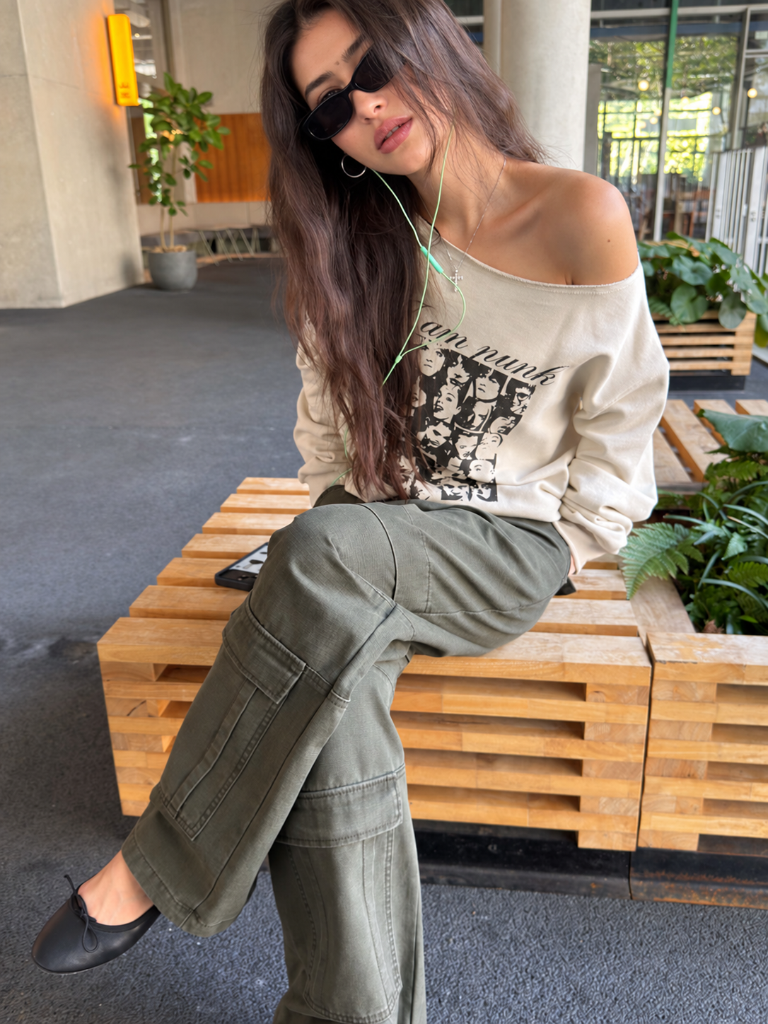 Off-Shoulder Cotton Graphic Top in cream – seated close-up with crossed legs