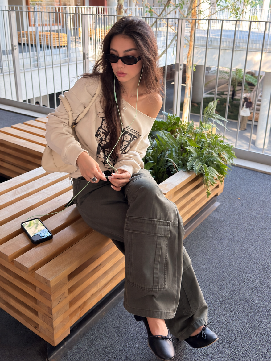 Off-Shoulder Cotton Graphic Top in cream – seated model wearing sunglasses