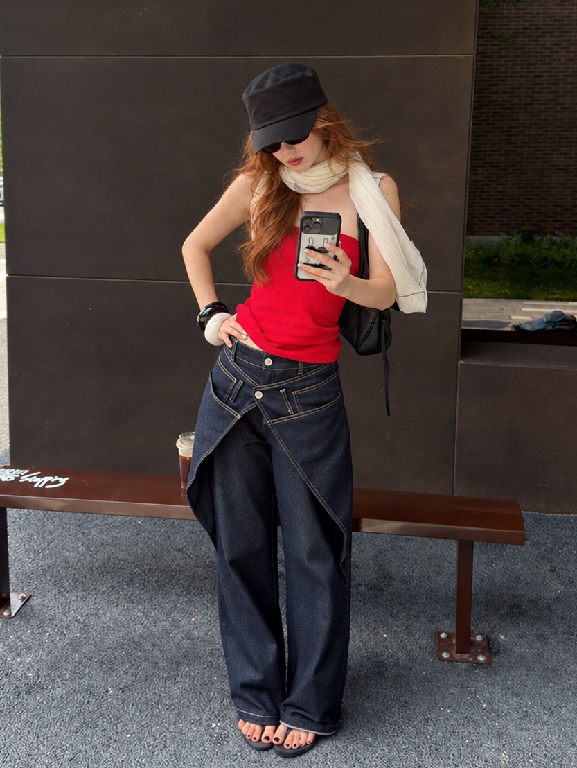 Model wearing Midnight Indigo Asymmetric Wrap Wide Leg Jeans with a fitted red tube top.