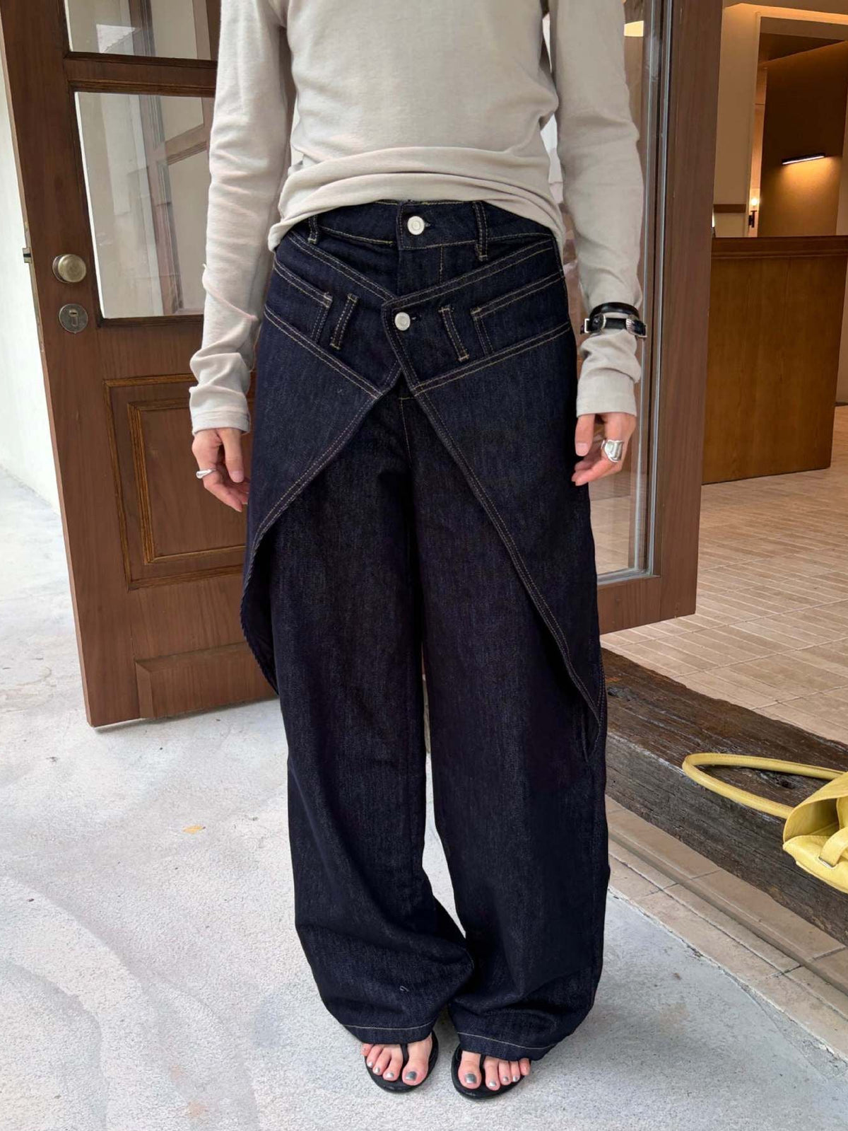 Close-up front view of Midnight Indigo Asymmetric Wrap Wide Leg Jeans highlighting the layered waistband detail.